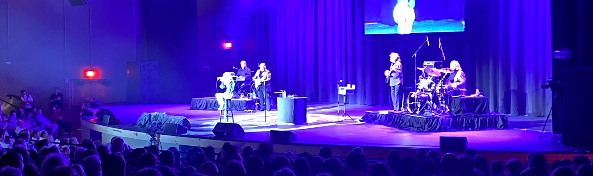 signer on stage in chair washed out by the lights Las Vegas